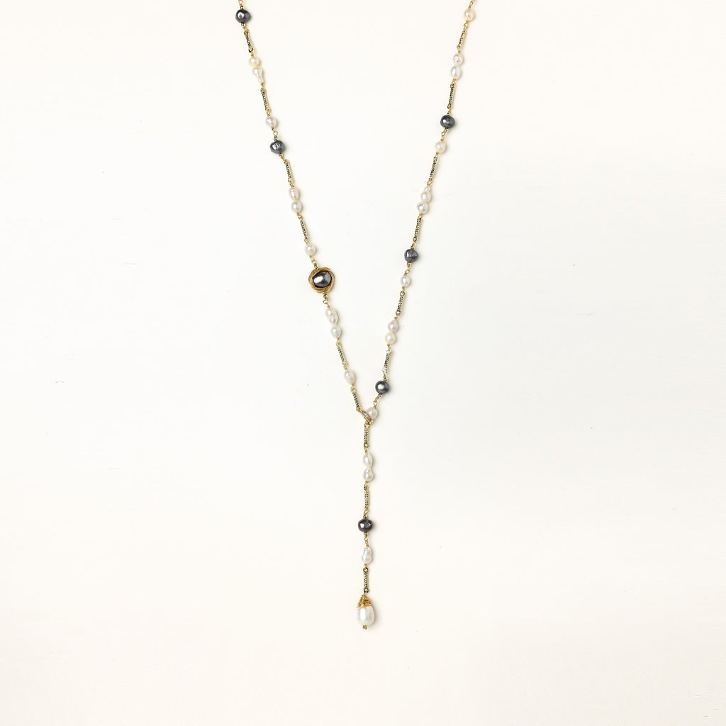 Long gold-plated necklace with alternating white and gray freshwater pearls spaced along delicate chain segments