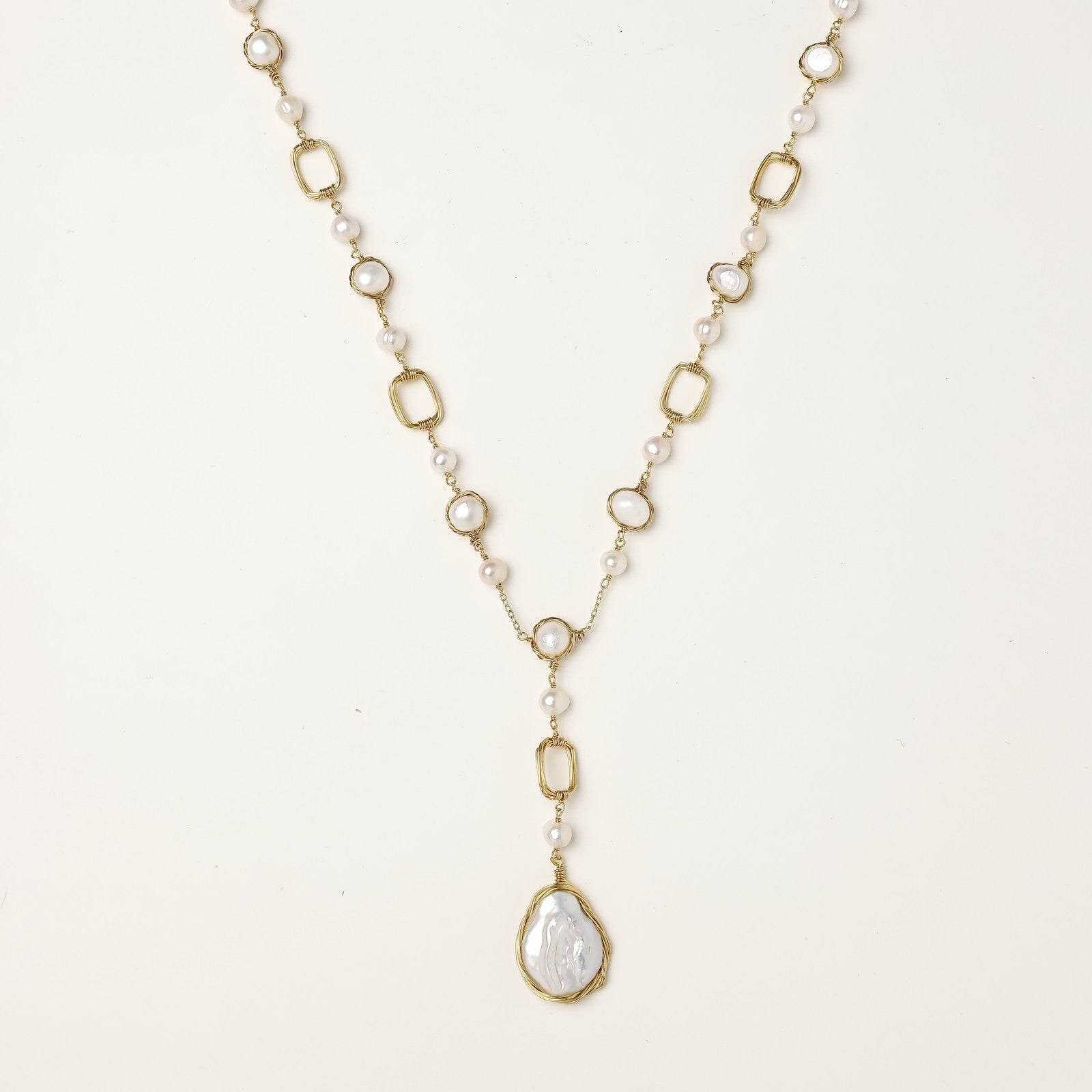 Y-shaped gold-plated necklace with freshwater pearls and geometric elements, featuring a baroque pearl pendant drop