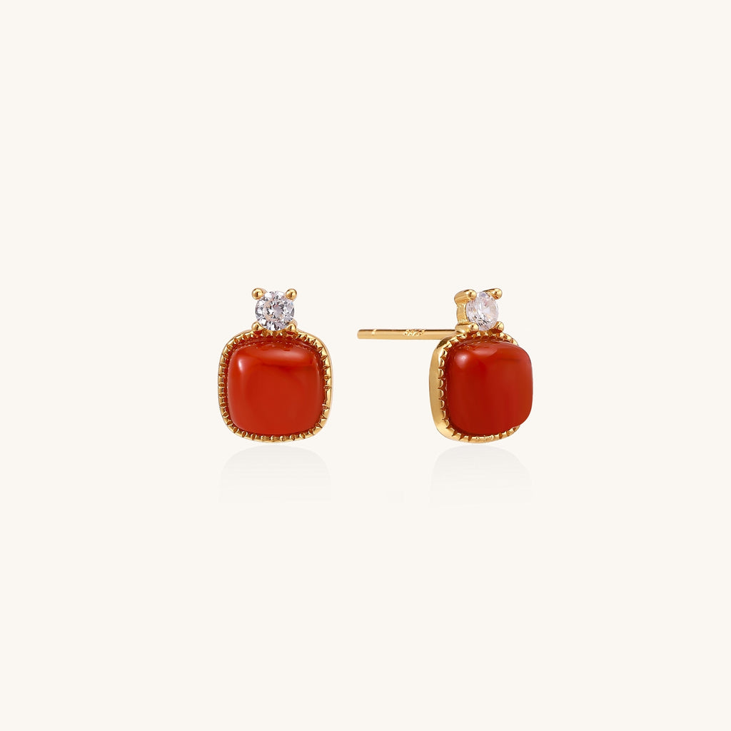 Gold-plated sterling silver stud earrings with square south red agate stones and clear crystals on cream background