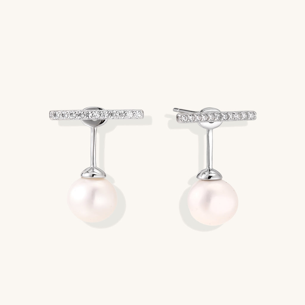 Sterling silver bar stud earrings with freshwater pearl drops on white background, minimalist jewelry design