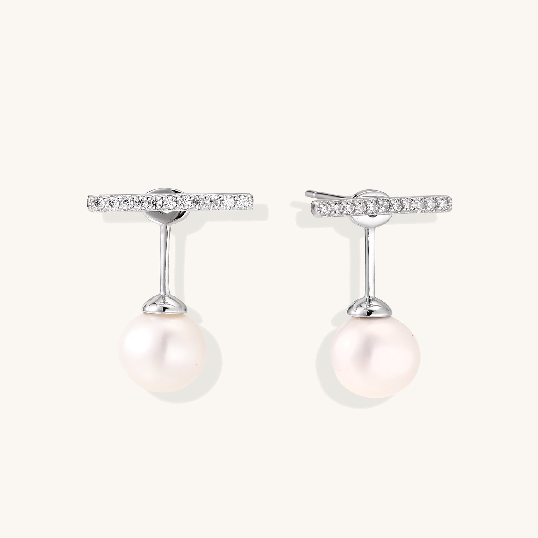 Sterling silver bar stud earrings with freshwater pearl drops on white background, minimalist jewelry design