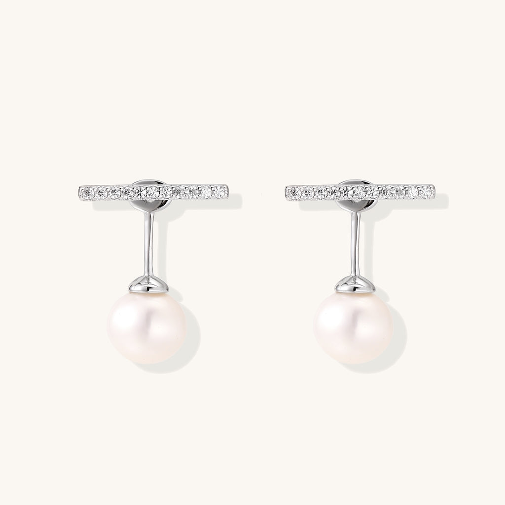 Sterling silver bar stud earrings with freshwater pearl drops on white background, minimalist jewelry design