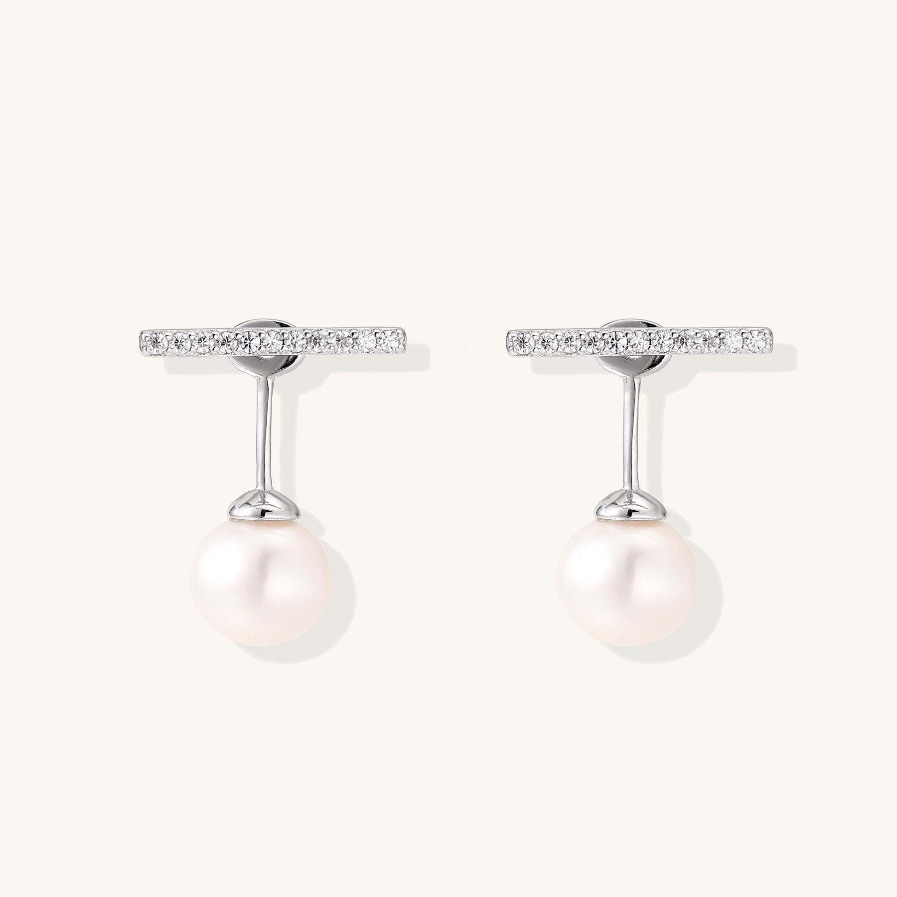 Sterling silver bar stud earrings with freshwater pearl drops on white background, minimalist jewelry design