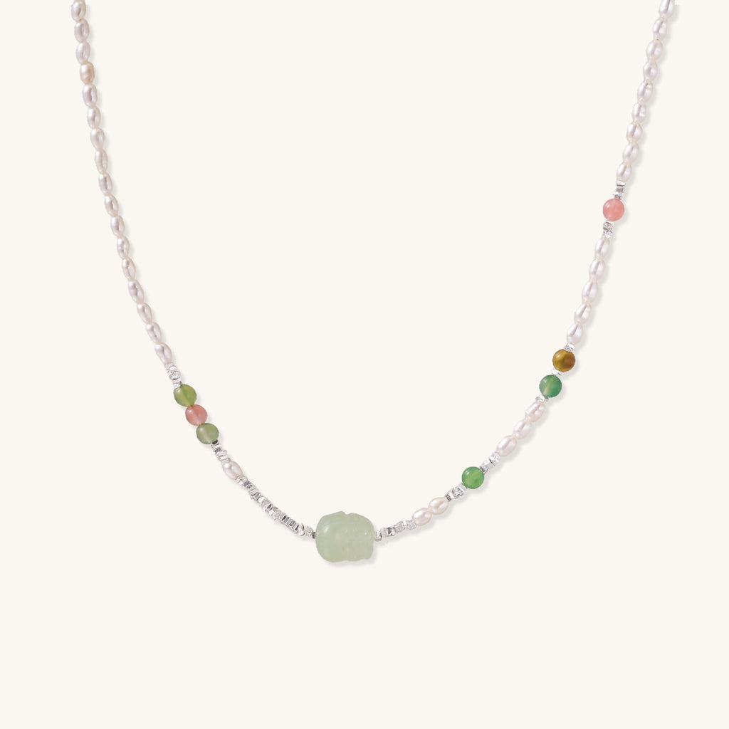 Delicate sterling silver necklace with freshwater pearls, green serpentine centerpiece, and mixed agate beads on white background.