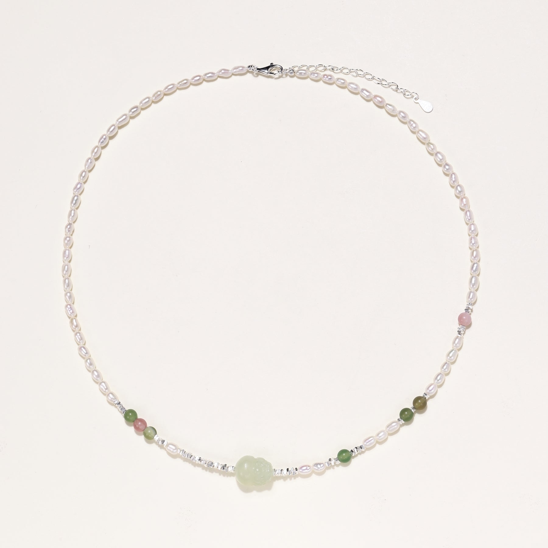 Delicate sterling silver necklace with freshwater pearls, green serpentine centerpiece, and mixed agate beads on white background.