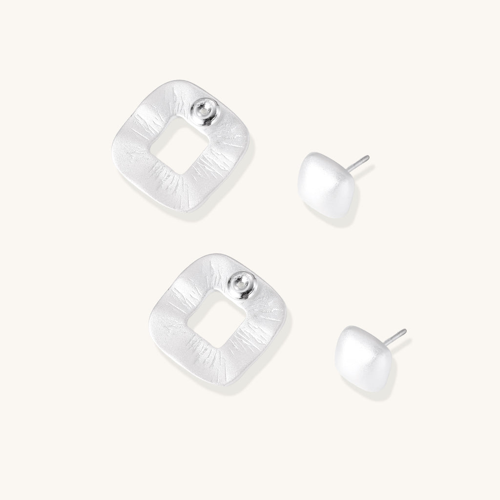 Geometric sterling silver square stud earrings with brushed texture and central square cutouts on white background.