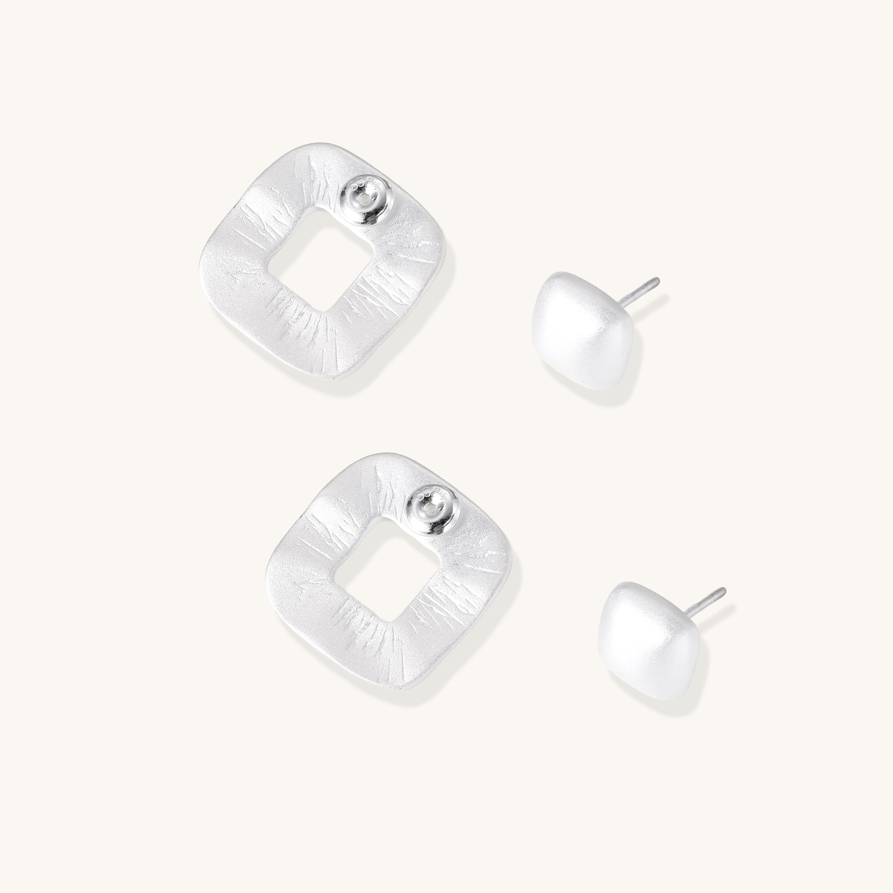 Geometric sterling silver square stud earrings with brushed texture and central square cutouts on white background.