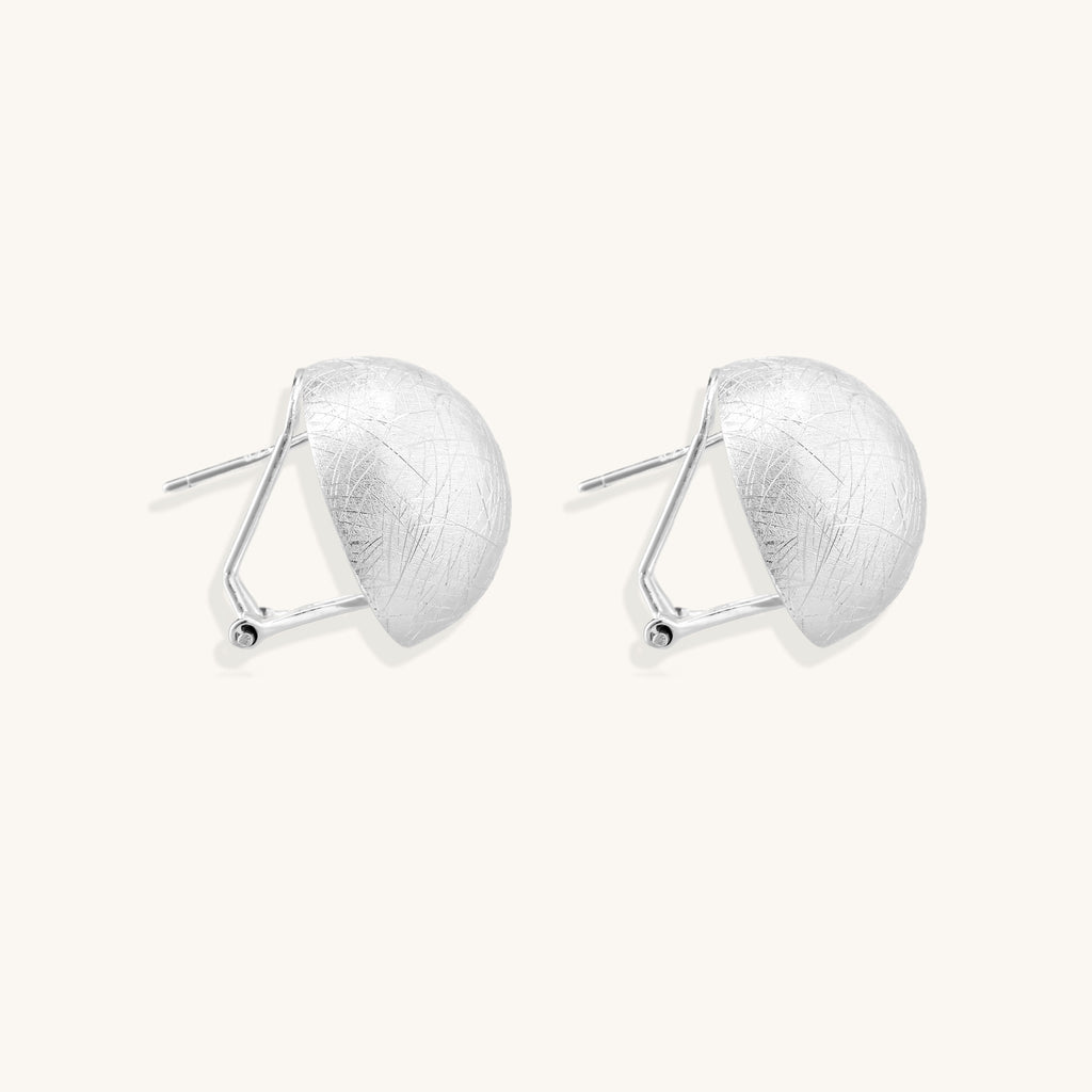 Brushed sterling silver dome-shaped stud earrings with textured surface and secure lever-back closure on white background.