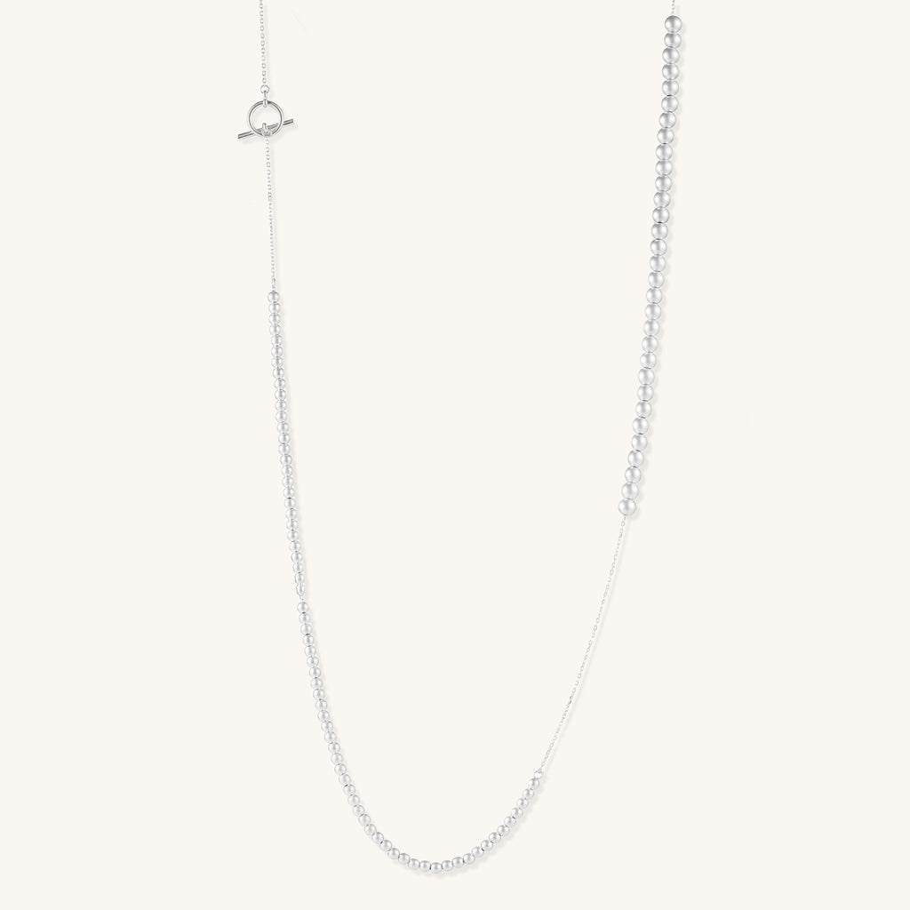 Sterling silver necklace with graduated pearl beads and delicate chain sections featuring a toggle clasp closure.