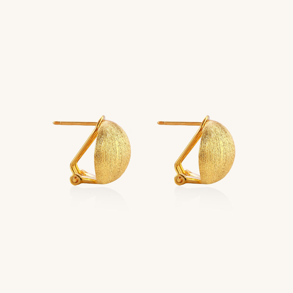 Close-up of textured gold-plated sterling silver dome clip-on earrings with brushed finish on white background.
