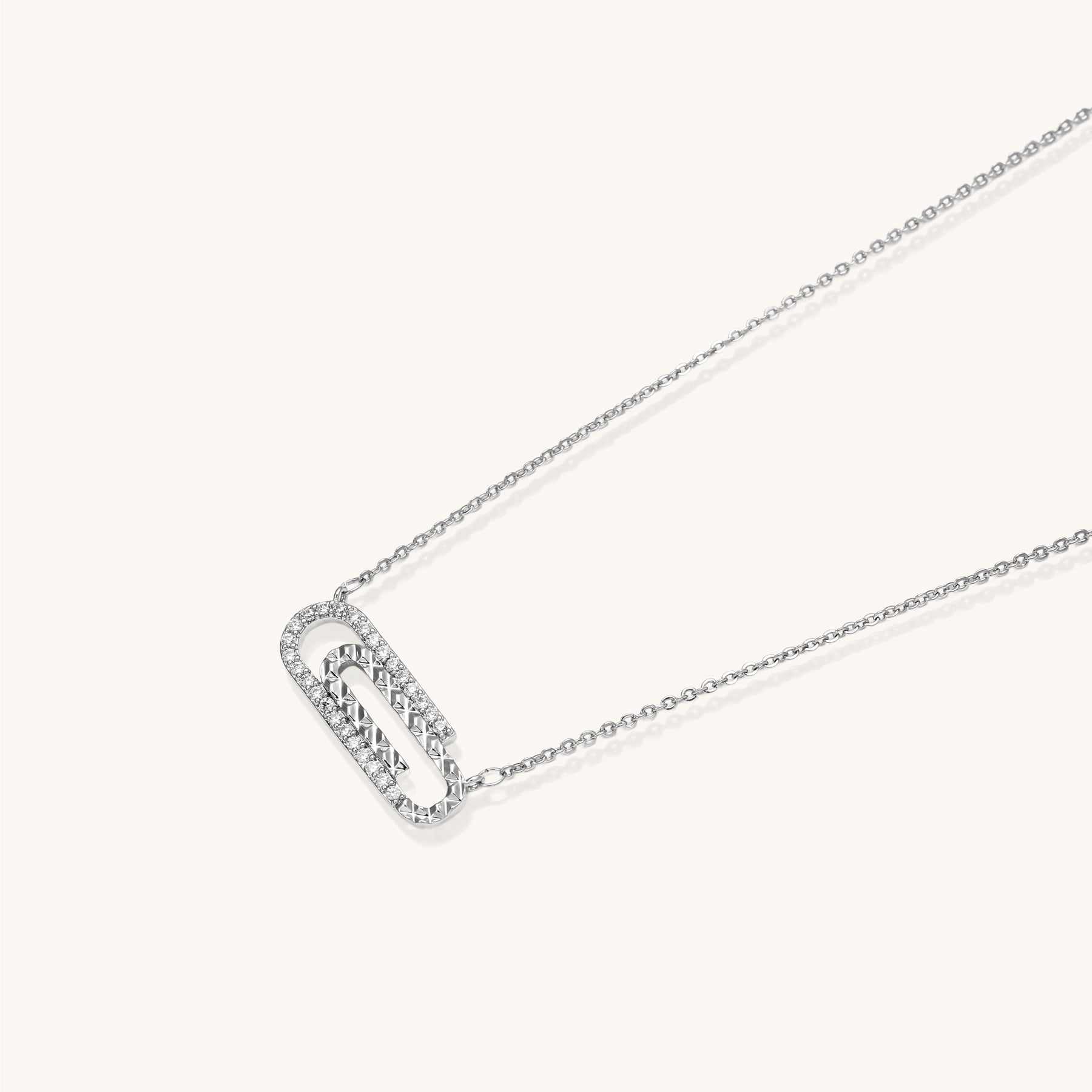 Delicate 14K gold plated chain necklace with crystal-accented carabiner-style pendant on white background