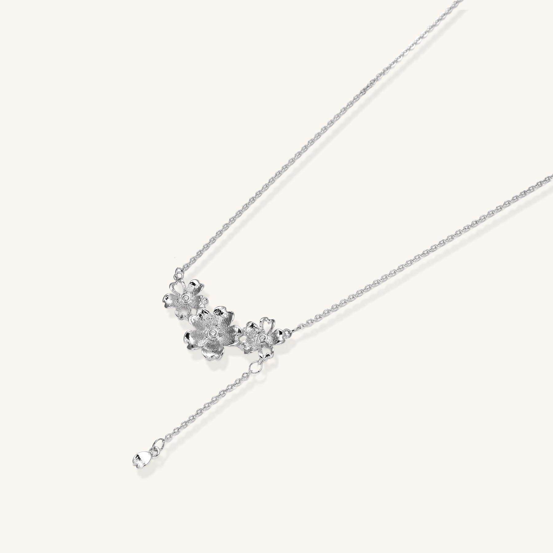 Delicate Y-style necklace with three textured flower pendants and adjustable chain in 14K gold plated brass finish.