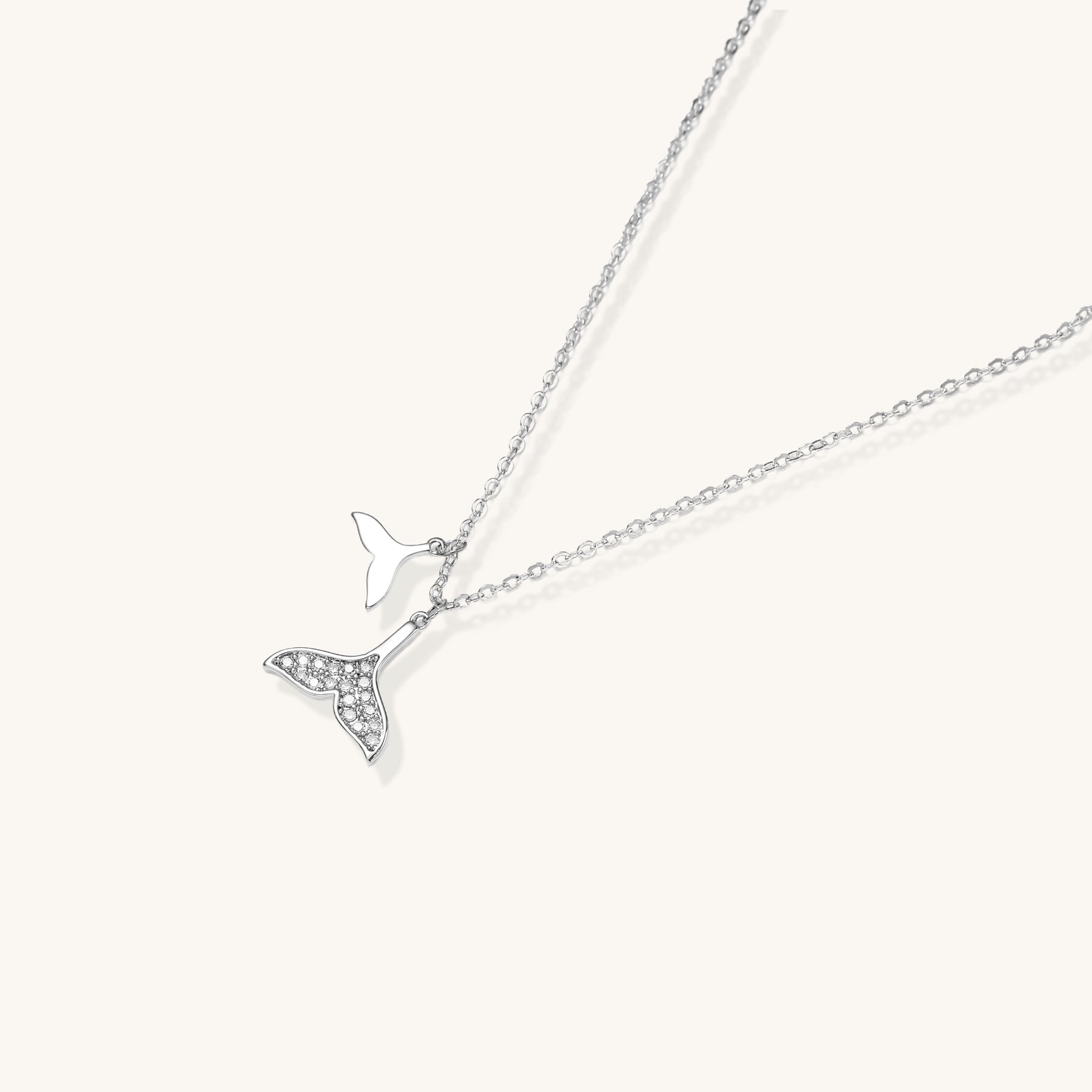 Delicate 14K gold-plated whale tail pendant necklace with sparkling crystal details on fine chain against white background.