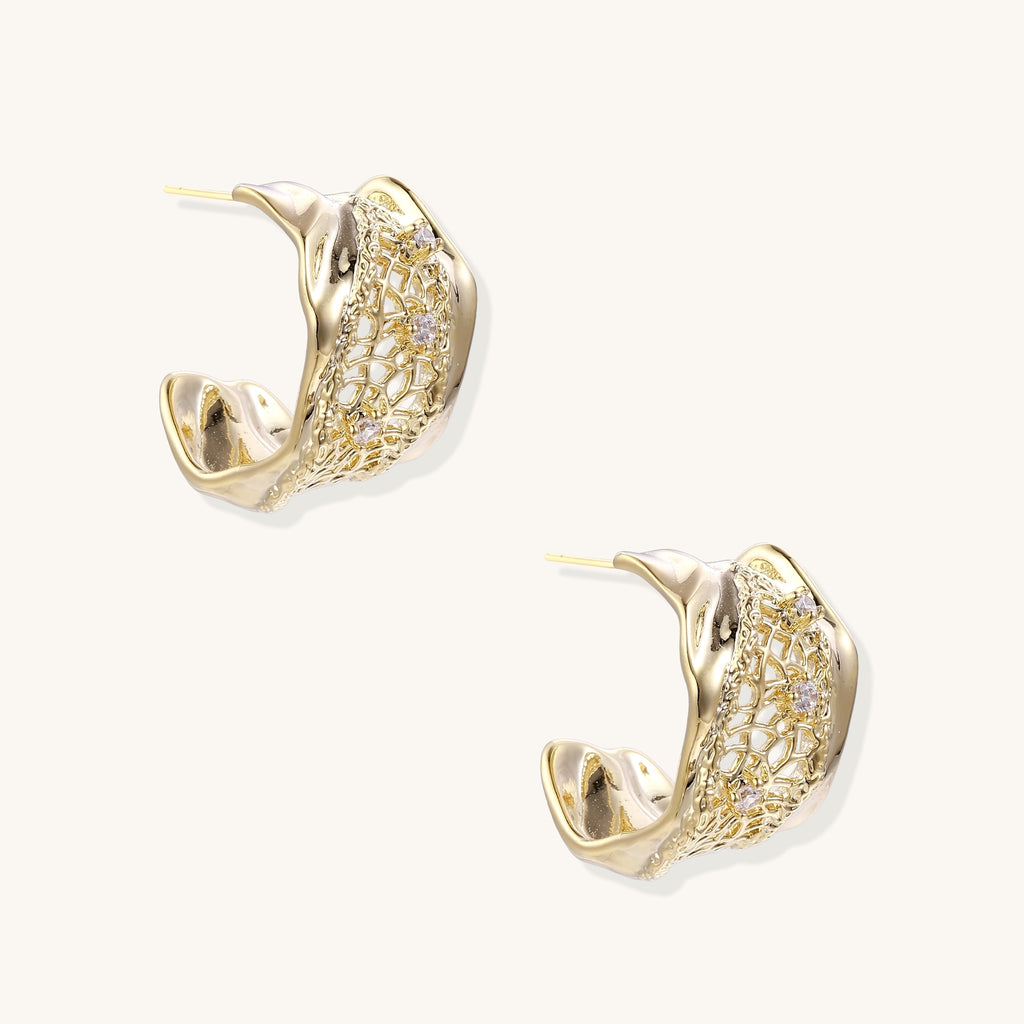 Close-up of gold-plated brass hoop earrings with geometric lattice pattern and sparkling zirconia stones