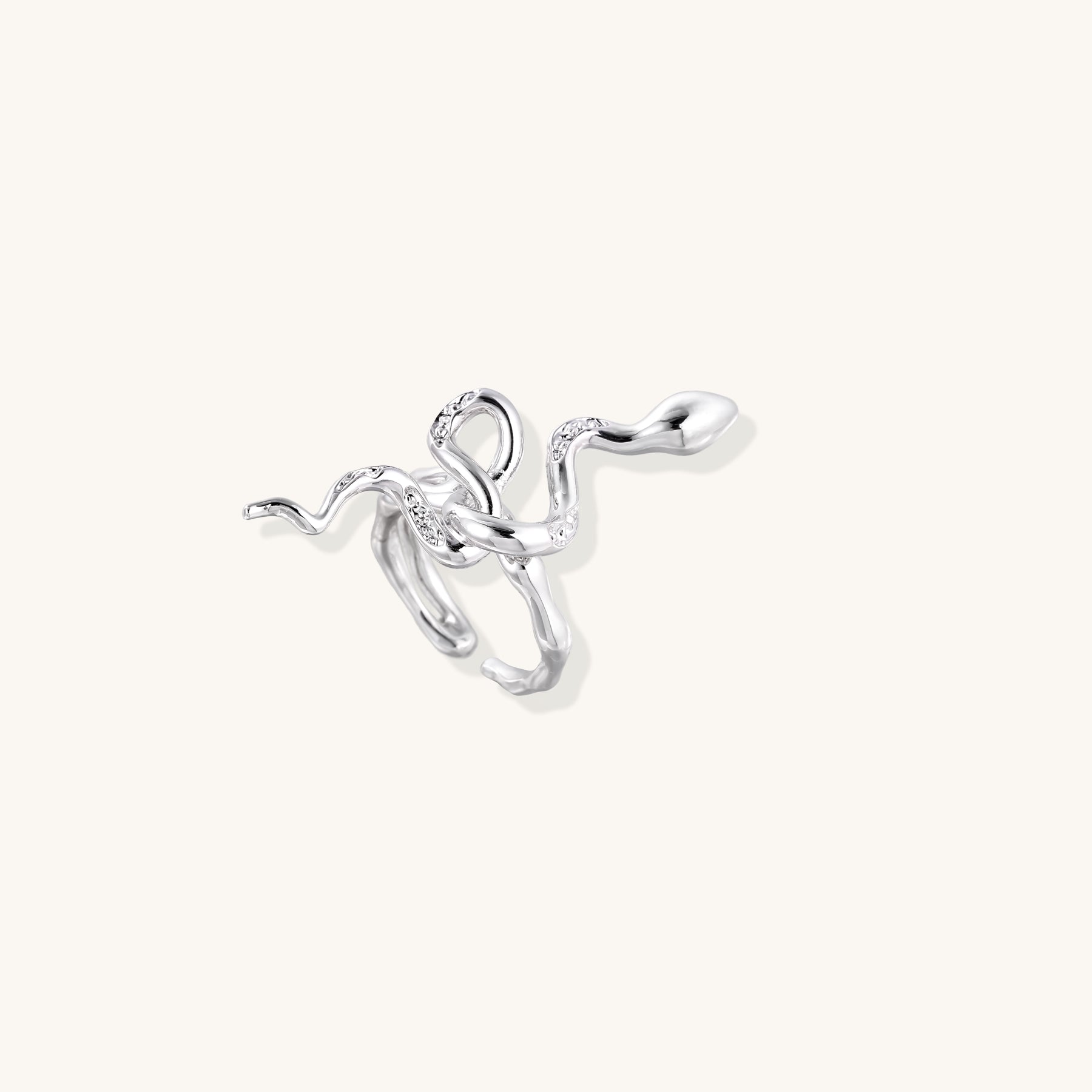 Gold-plated brass snake ring with flowing curves and crystal accents, wrapping around finger in sculptural design