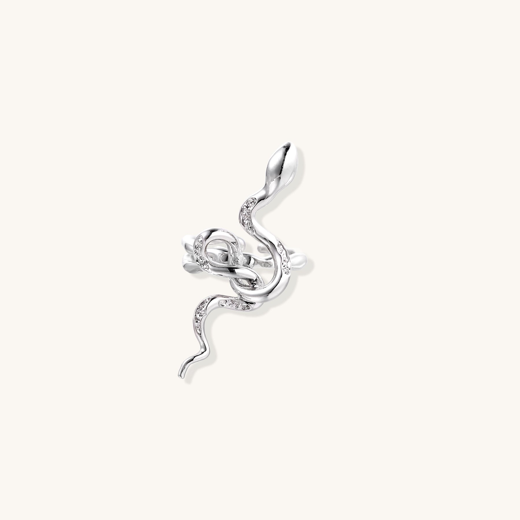 Gold-plated brass snake ring with flowing curves and crystal accents, wrapping around finger in sculptural design