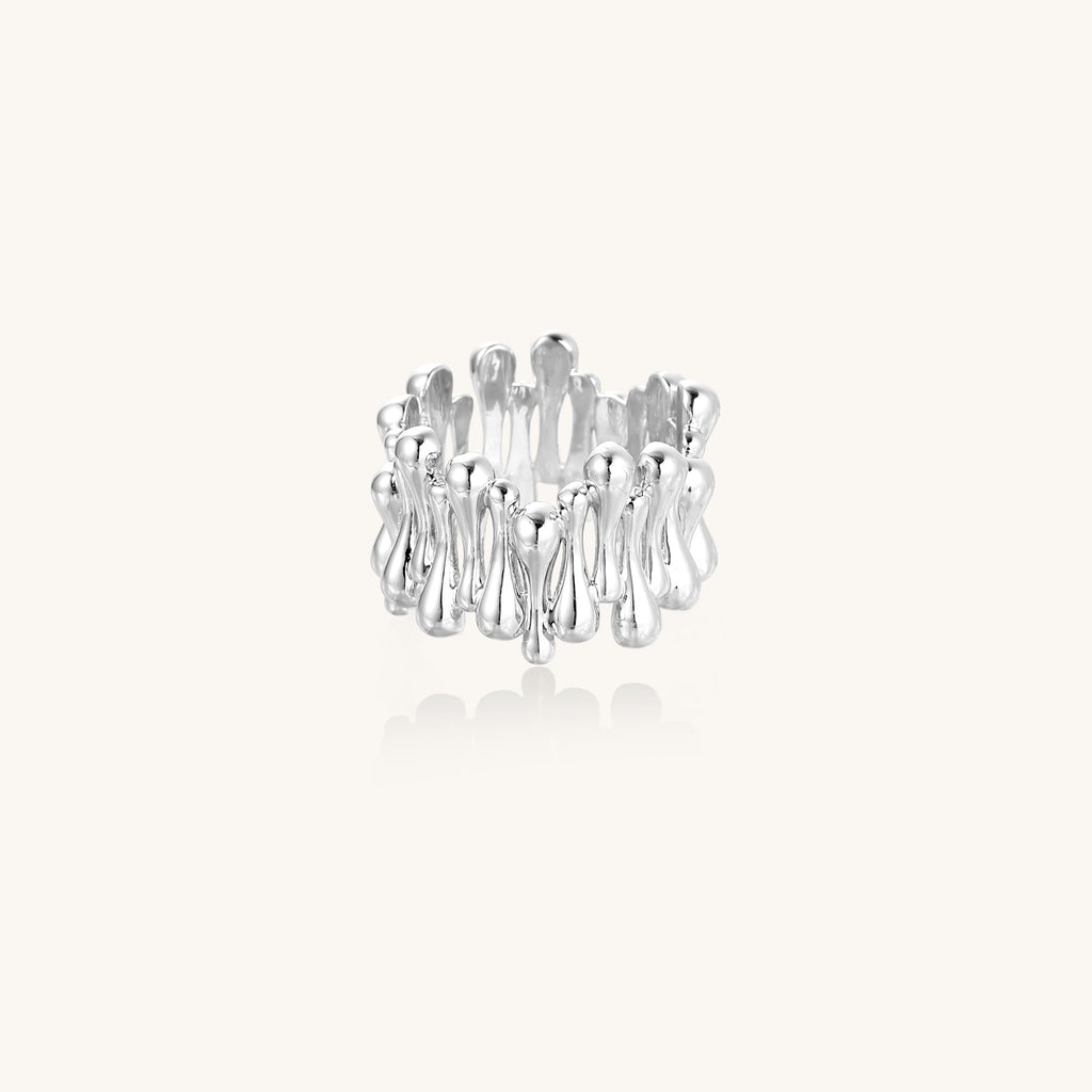 Close-up of an artistic gold-plated brass ring with multiple twisted bands creating a sculptural flowing design