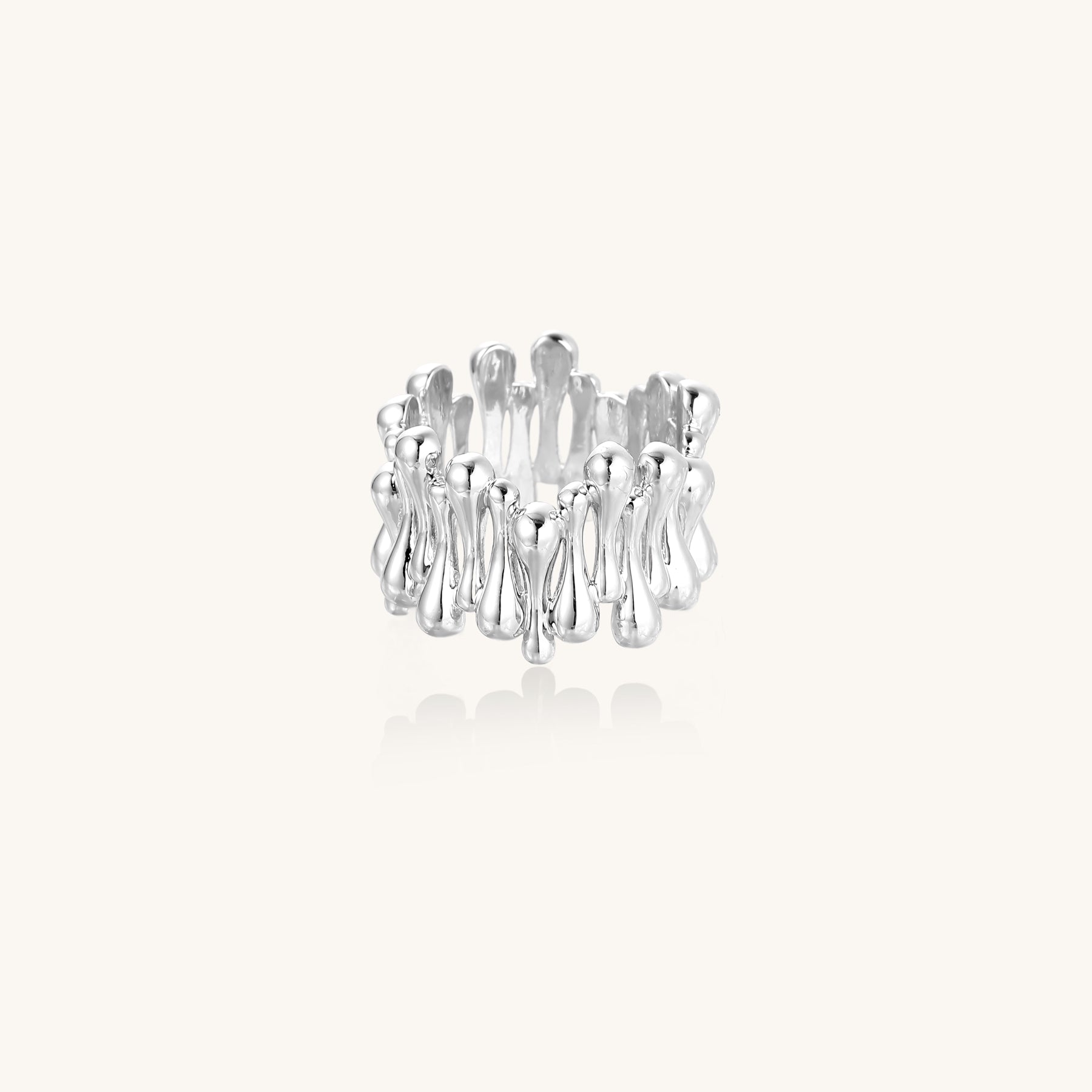 Close-up of an artistic gold-plated brass ring with multiple twisted bands creating a sculptural flowing design
