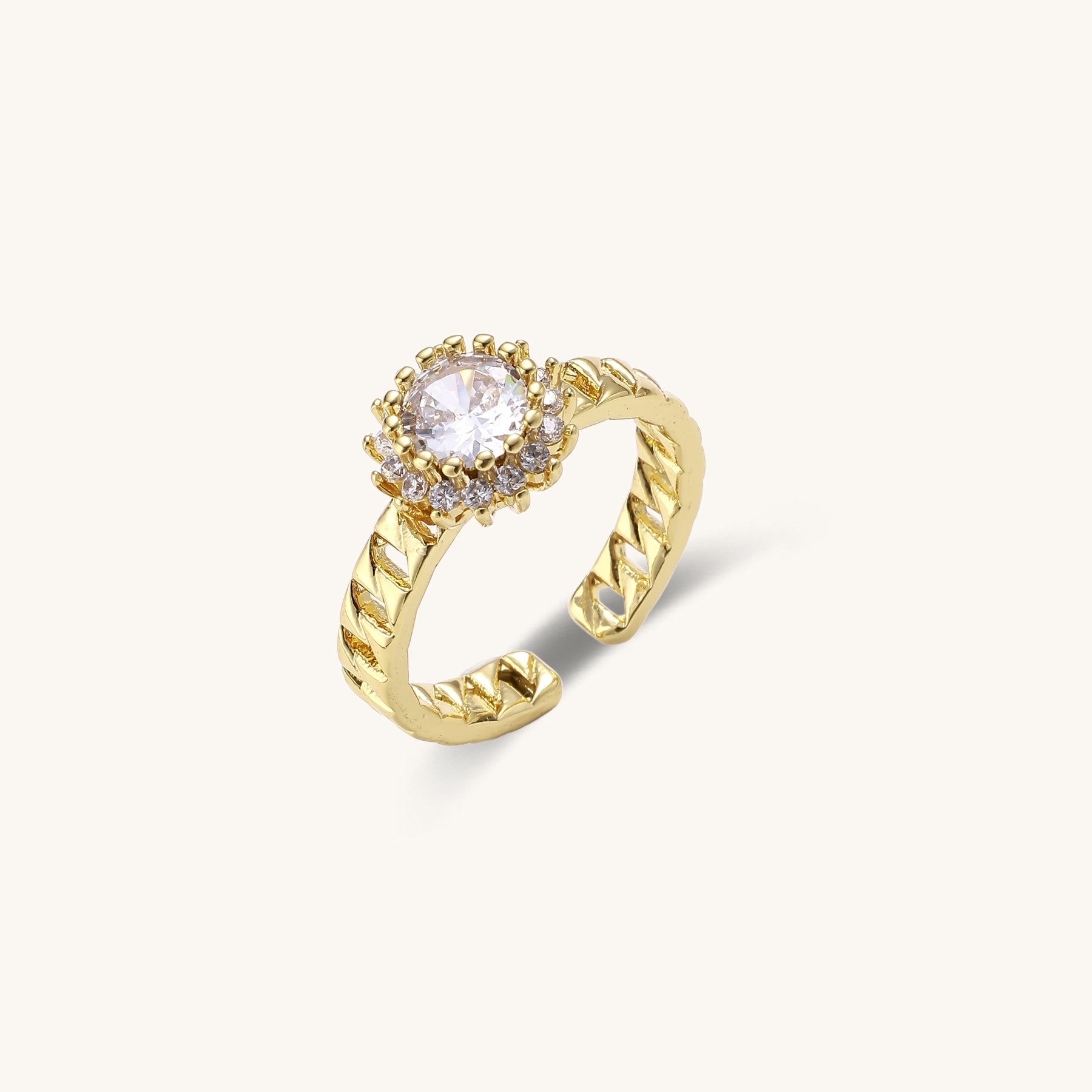 Two gold-plated brass rings with chain-link bands, one featuring a round cubic zirconia halo, one with black enamel accent.