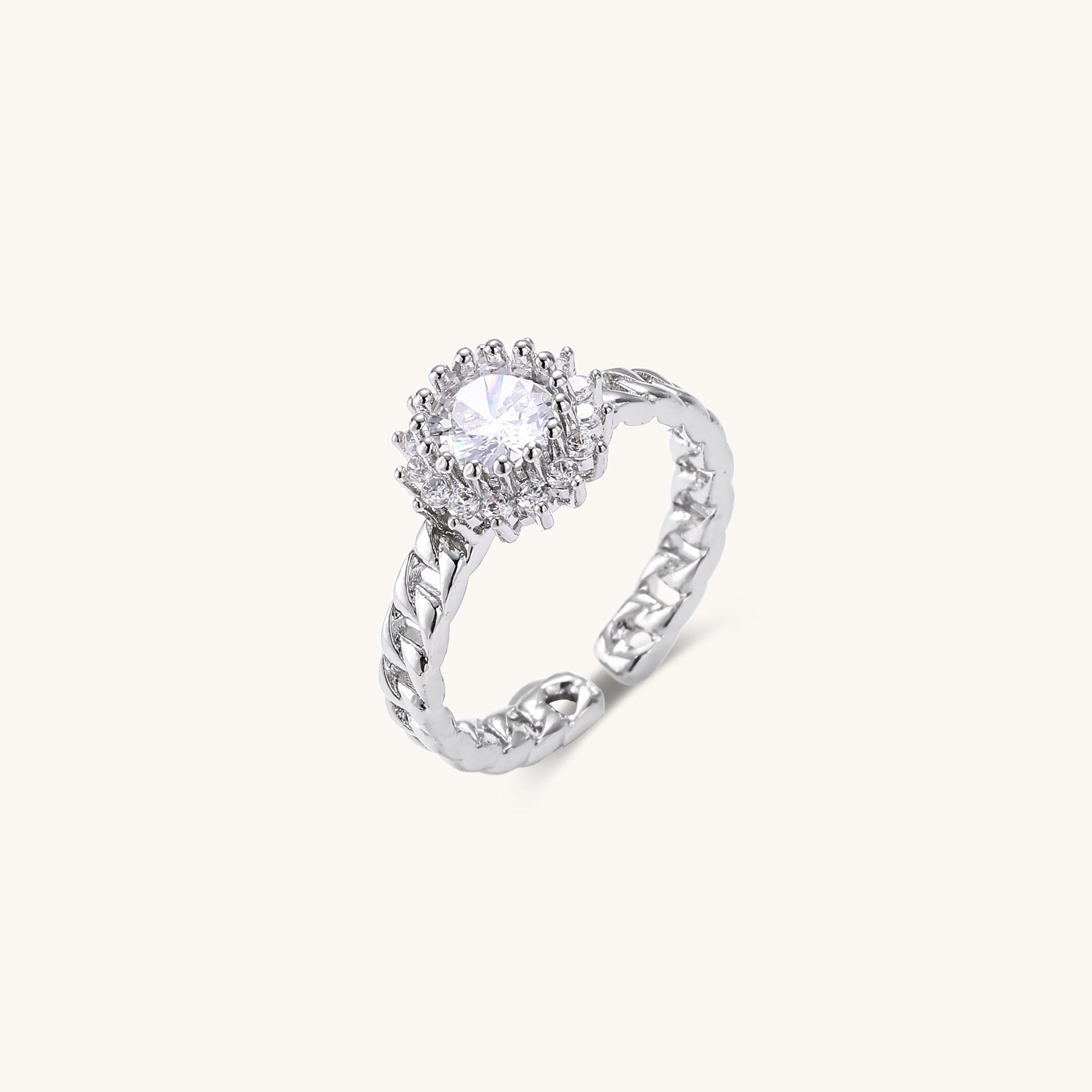 Two gold-plated rings with chain-link bands, one featuring cubic zirconia halo setting, displayed on neutral background
