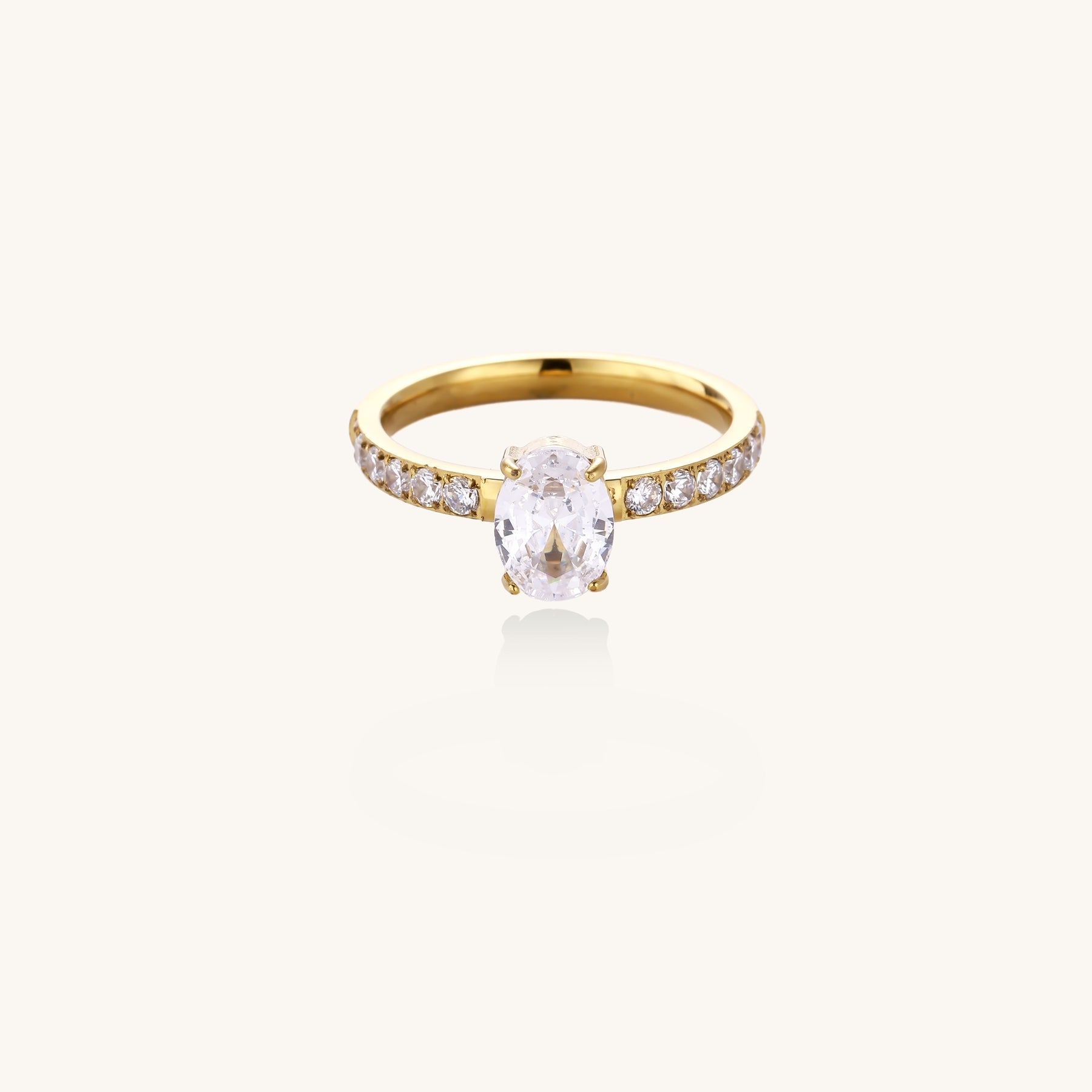 14K gold-plated ring with oval zirconia center stone and pavé band accent stones on white background.