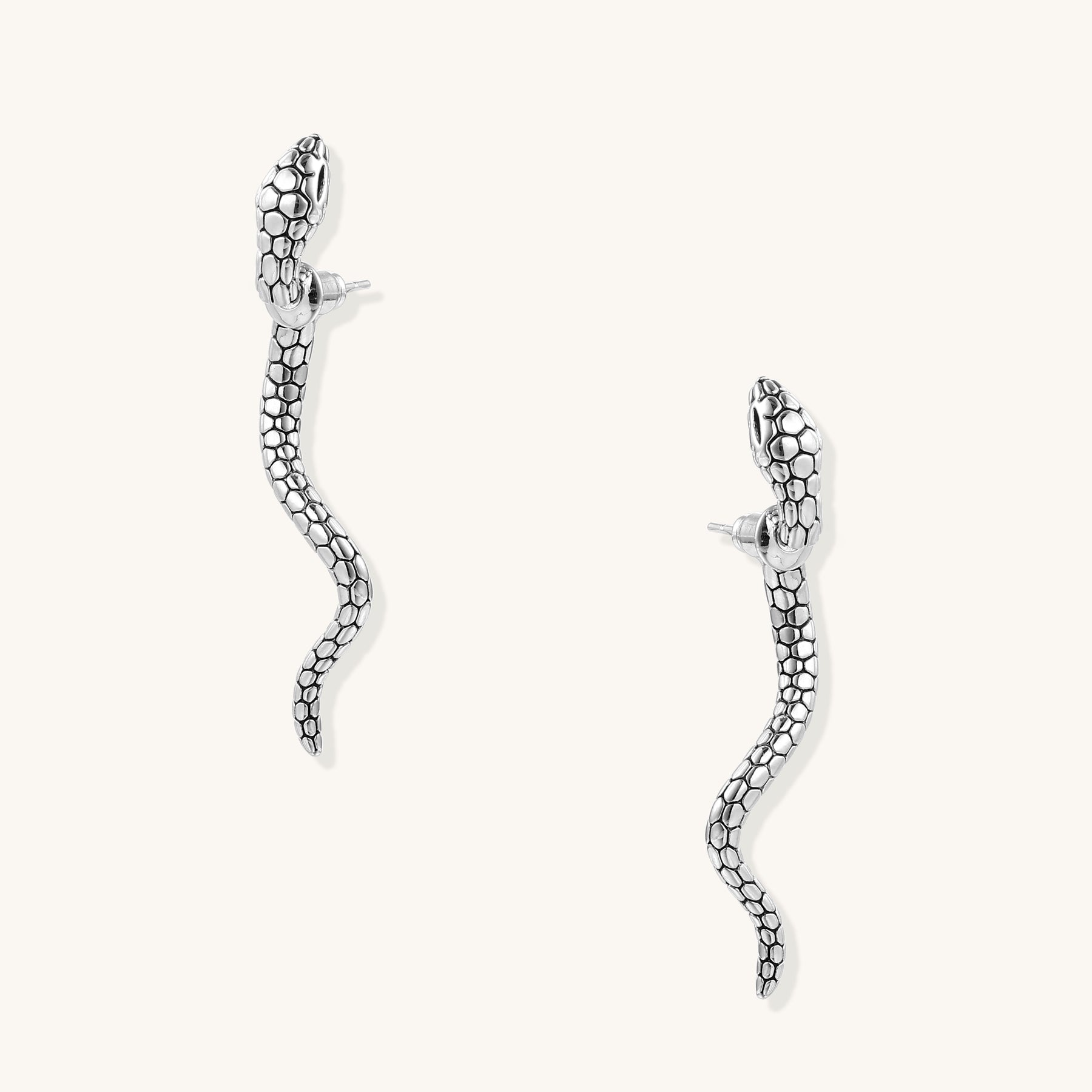 Pair of gold-plated brass snake drop earrings with detailed scale texture and curved serpentine design against white background