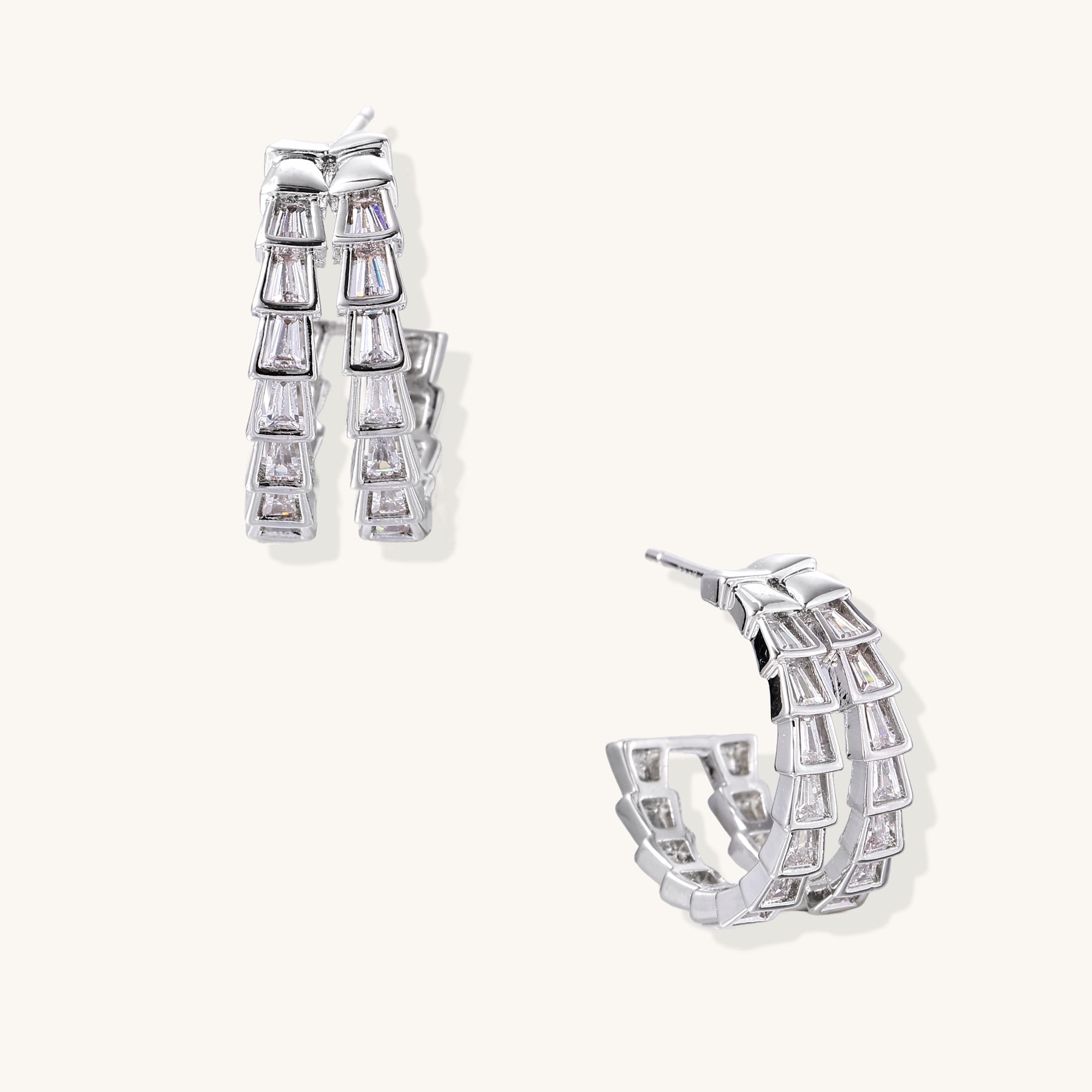 Gold-plated huggie hoops featuring vertical rows of clear baguette zirconia stones in geometric linear design