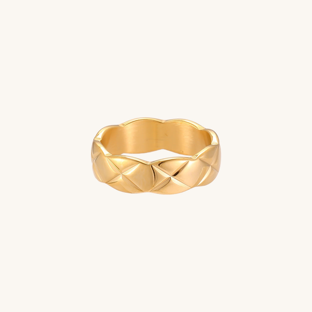 18K gold plated stainless steel ring with geometric twisted band design on neutral background
