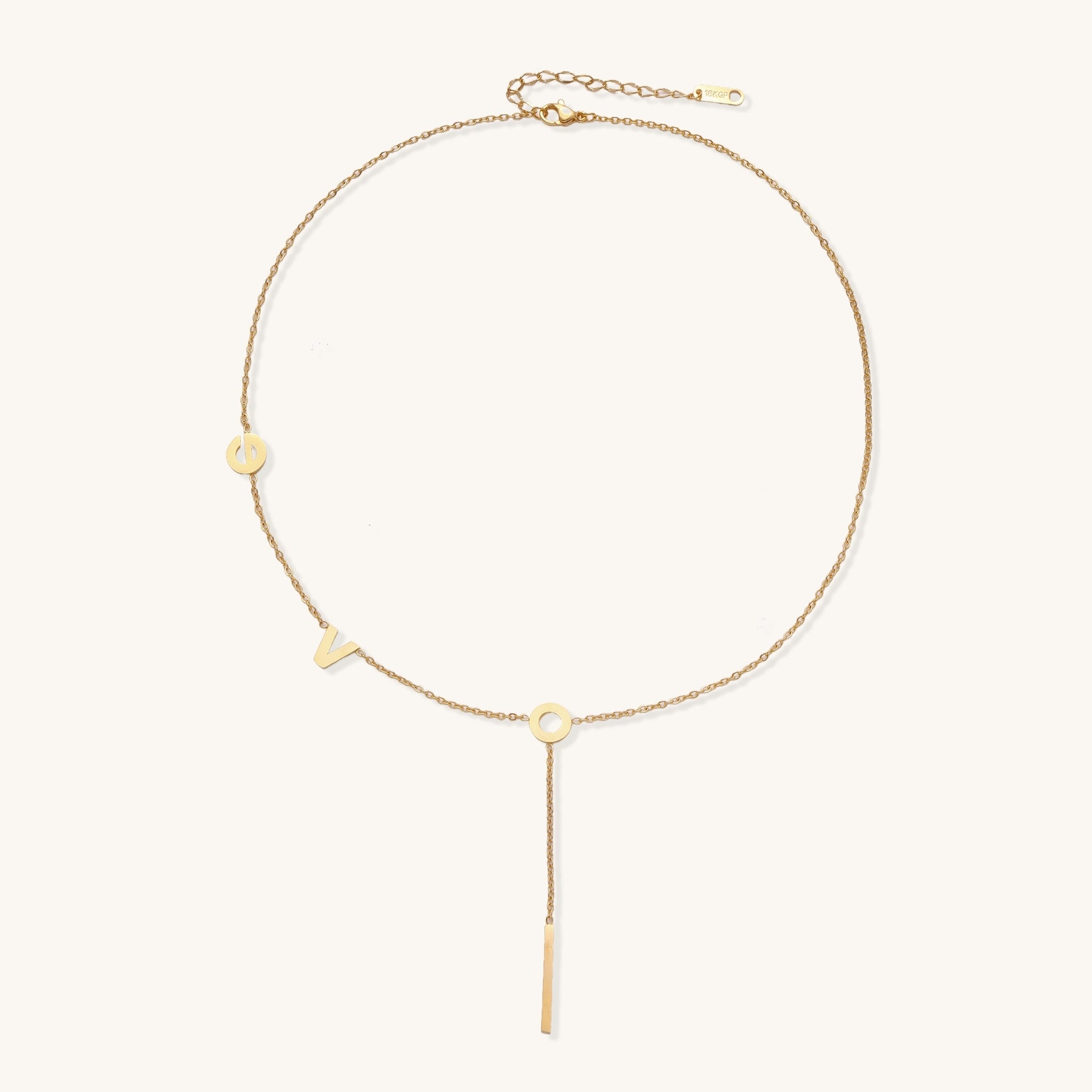Gold-plated lariat necklace spelling LOVE with letter charms and vertical bar pendant on white background.